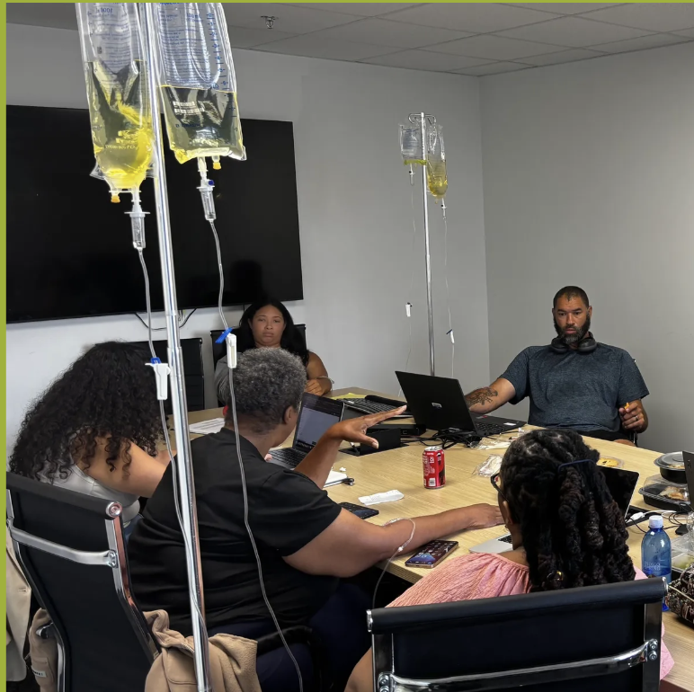 Clients enjoying an IVybe drip party around a conference table