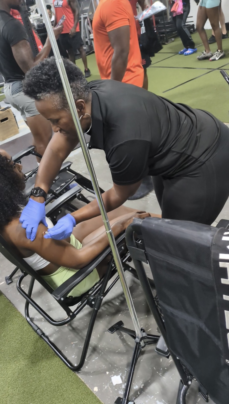 Cheryl placing an IV for a client at a community fitness day event