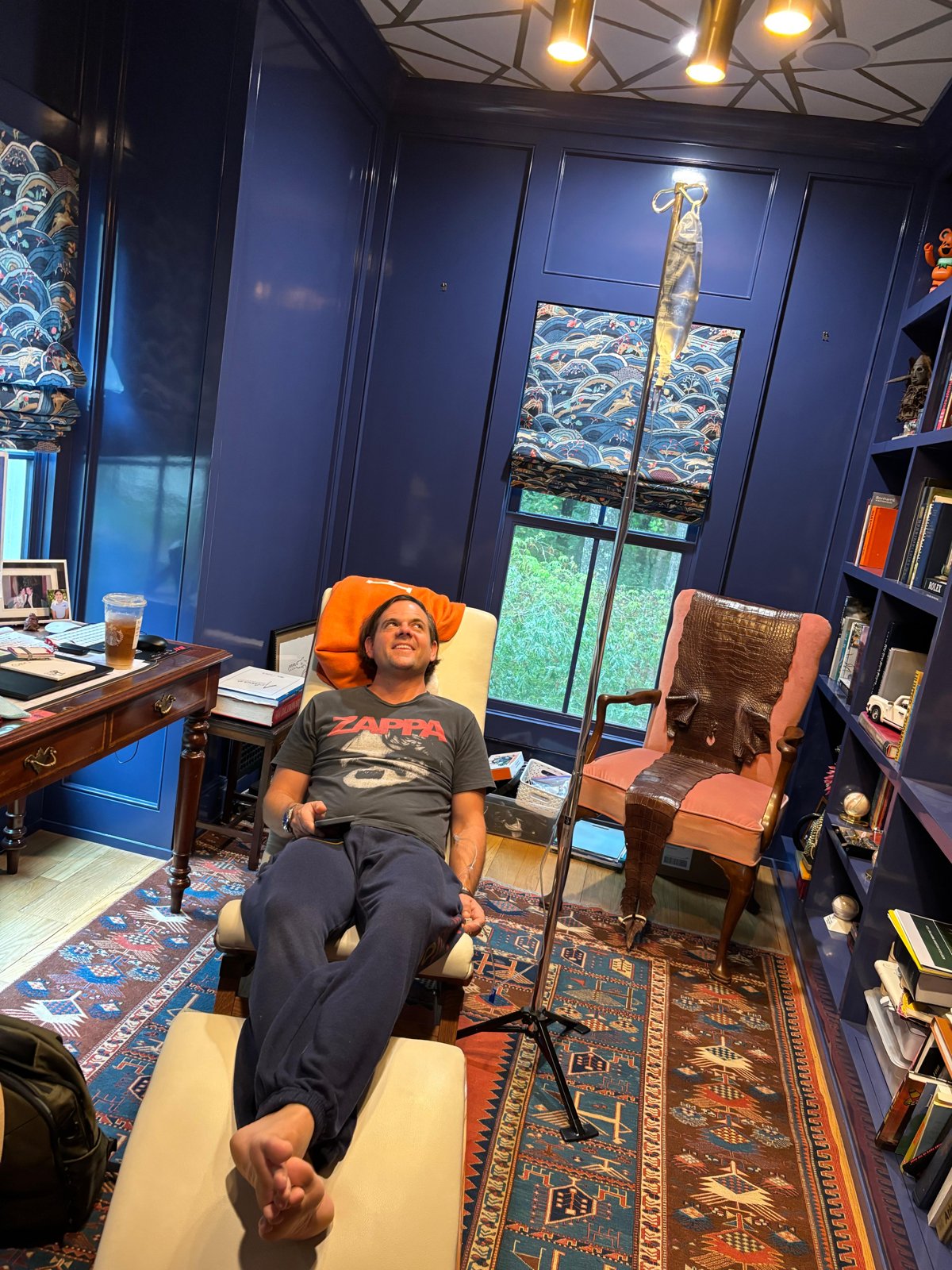 Client relaxing with an IV drip in his personal home library