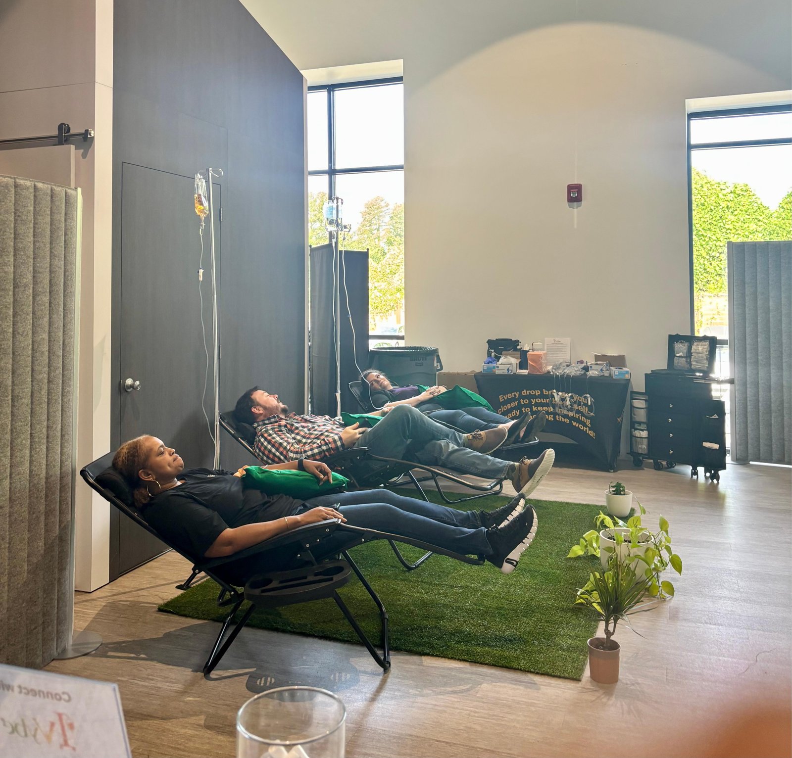 Clients reclining in zero-gravity chairs at an on-site corporate wellness setup